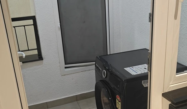 Dedicated utility balcony in the Nambiar District 25 4 BHK model flat, featuring a washing machine provision, anti-skid flooring, and a secure safety railing